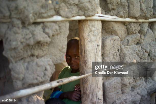 Young boy stands in a mud hut at the Kerwa Receiving Centre after being brought from the South Sudanese border on February 23, 2017 in Kuluba,...