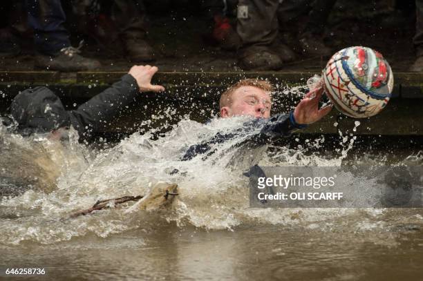 Competitors reach for the ball during the annual Royal Shrovetide Football Match in Ashbourne, northern England, on February 28, 2017. The...