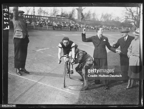 Carl Brisson, the actor, prepares to fire the starter's pistol for the Great Olympic Revenge race between cyclists Henry Hansen and F.W. Southall.