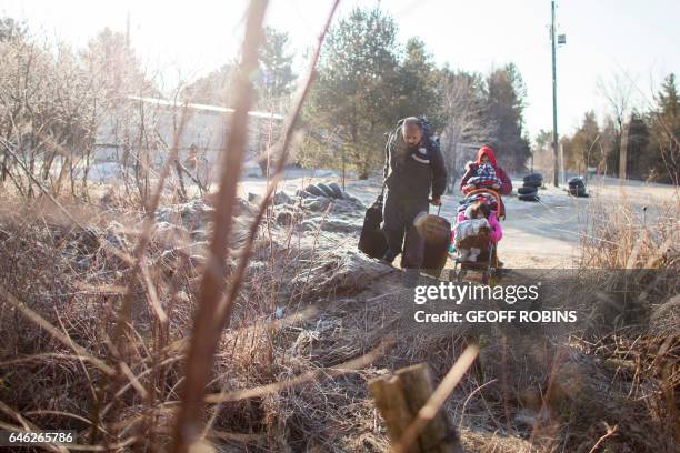 Family of four from Pakistan prepare to cross the US-Canada border near Hemmingford, Quebec, February 28, 2017.