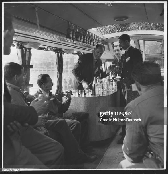 Journalists at the bar in the Press coach at the Monte Carlo motor rally. In the background is John Field, editor of Transport, and on the left is...