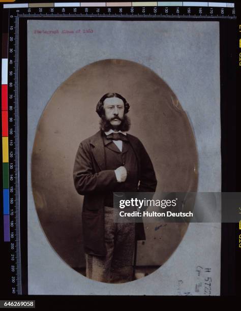 Victorian Gentleman with side whiskers, stands with his hands inside his waistcoat pocket, ca. 1860.