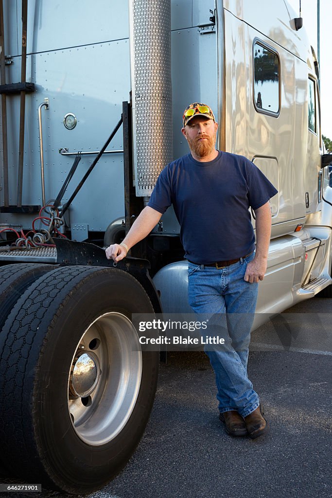 Trucker Portrait leaning on Tire