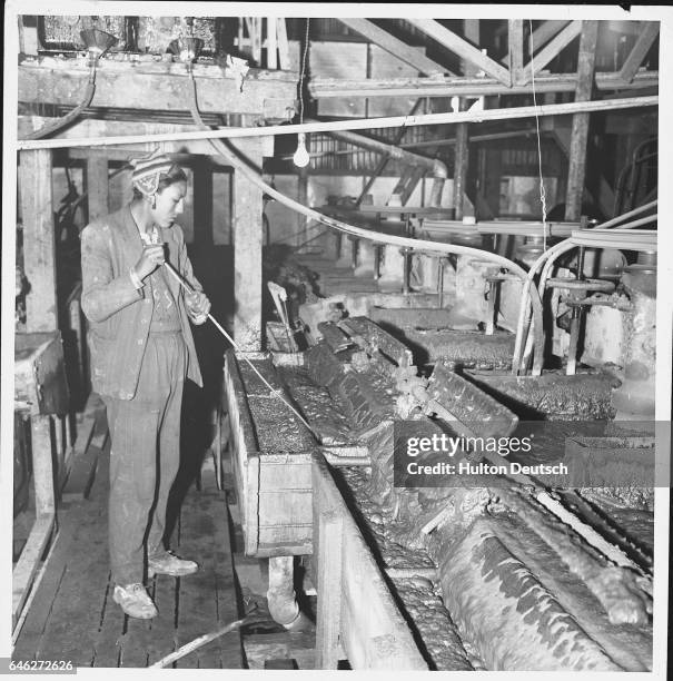 Indian worker stirring an ore bath in wolfram mine Esquillache near Puno on Lake Titicaca.