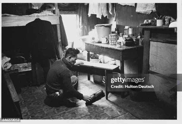 Chinese man picks up a toy in a room in a hostel for Chinese in Liverpool.