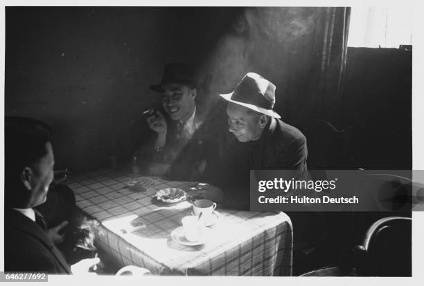 Several Chinese laborers relax in the dining room of a workers hostel in Liverpool.