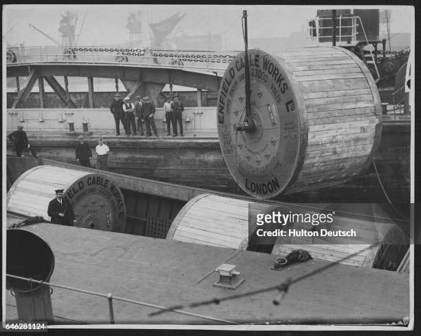 Electricity cables from the Enfield works in London are lifted from a boat.