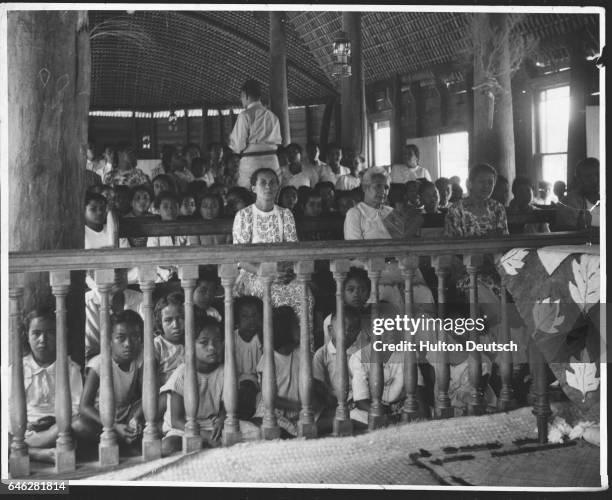 Children sit at the front of the congregation, behind the altar rail, in the Wesleyan church at Ohonua, the chief village on the Tongan island of Eua.