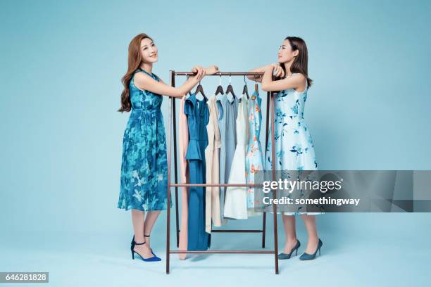 sisters in the clothing store to buy clothes - blue dress hanger stock pictures, royalty-free photos & images