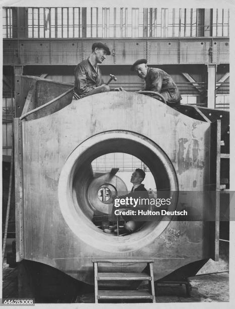 Workmen at work on the castings for the stern of a new Cunard ocean liner. The man at the bottom is working in the hole that takes the rudder post.