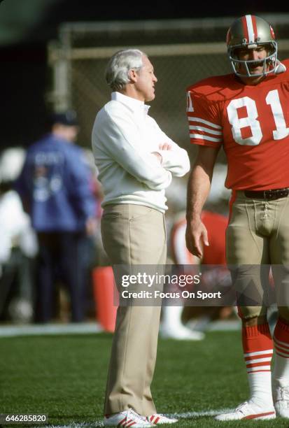 Head coach Bill Walsh of the "nSan Francisco 49ers talks with tight end Russ Francis during pregame warm ups prior to the start of an NFL Football...