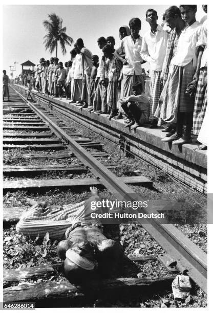 Crowds look at a dead collaborator on the railway track at Jhikargacha during the war between India and Pakistan. | Location: Jhikargacha.