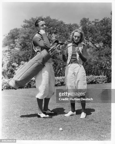 American film actor Robert Young playing golf with American film actress Karen Morley, circa 1930s.