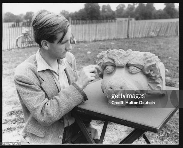 Archaeologist Alan Millard examining a 13th century gargoyle from Merton Priory, the stone work of which was used in the building of the palace, and...