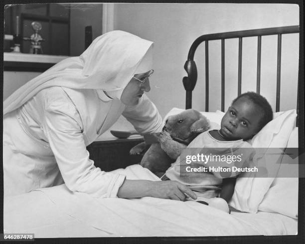 Sister Mary Catherine talks to a Biafra child who was a victim of the Nigerian Biafran War and is in Britain for medical care.