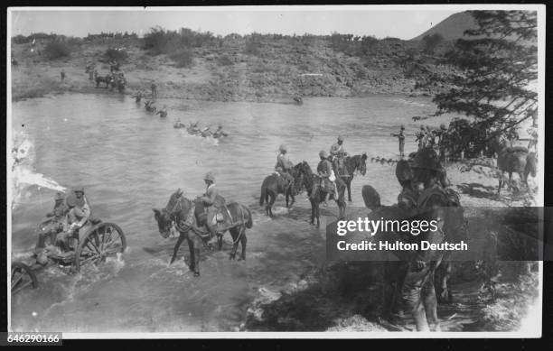 Members of the British Infantry crossing the River Modder with the aid of lifelines. | Location: Modder River, South Africa.