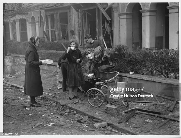 Salvation Army workers take a much-needed tea break while salvaging pieces of furniture from the bombed ruins of homes in Dulwich, England.