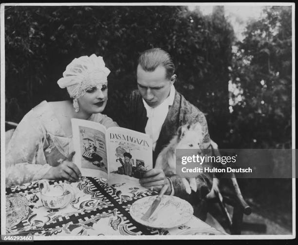 German heavyweight boxing champion Kurt Prenzil and his wife, silent film star Baroness Fern Andra, read a magazine together at their home in Berlin.