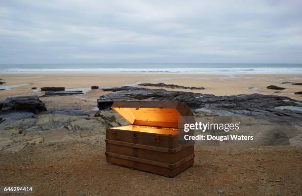 open treasure chest of gold on a deserted beach. - chest fotografías e imágenes de stock
