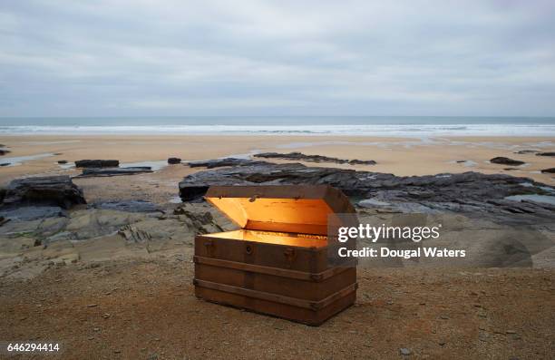 open treasure chest of gold on a deserted beach. - schatkist stockfoto's en -beelden