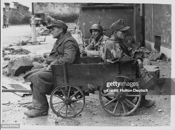 Two German prisoners captured in Aachen await transport, October 1944.