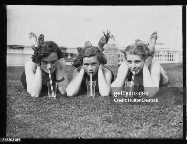 Three young girls quench their thirst at Finchley Open Air Baths.