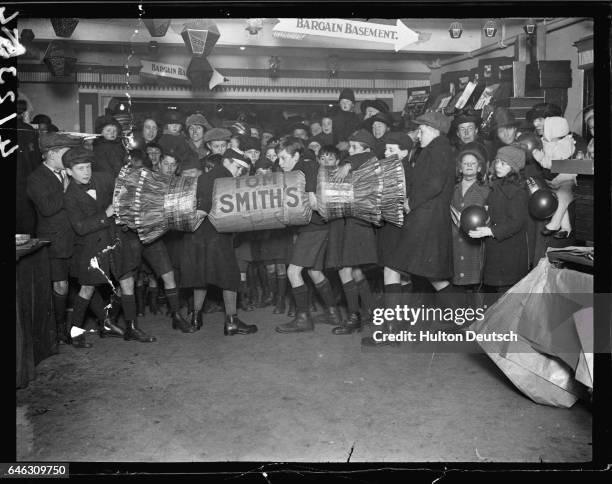 School boys attempt to pull apart a giant cracker during Christmas festivities at the Arding and Hobbs department store.