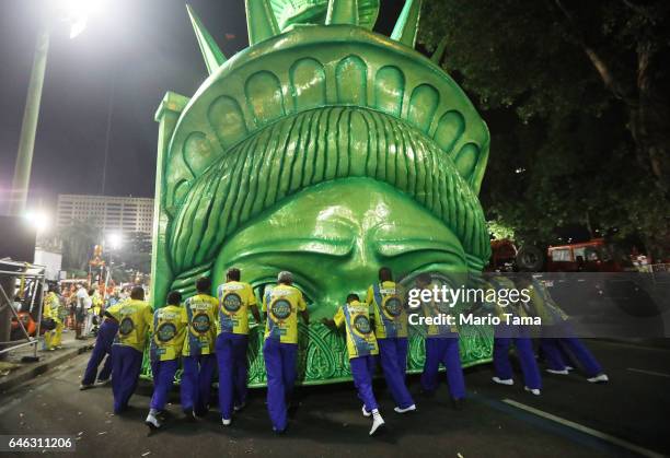 Revelers from the Tijuca samba school prepare to perform while pushing a Statue of Liberty-themed float outside the Sambodrome in the early morning...