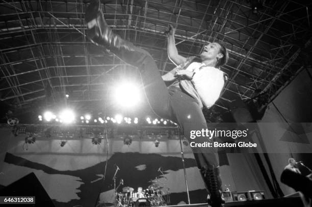 Lead vocalist Bono of U2 kicks in the air as the band performs at Sullivan Stadium in Foxborough, MA on Sep. 22, 1987 during their tour supporting...