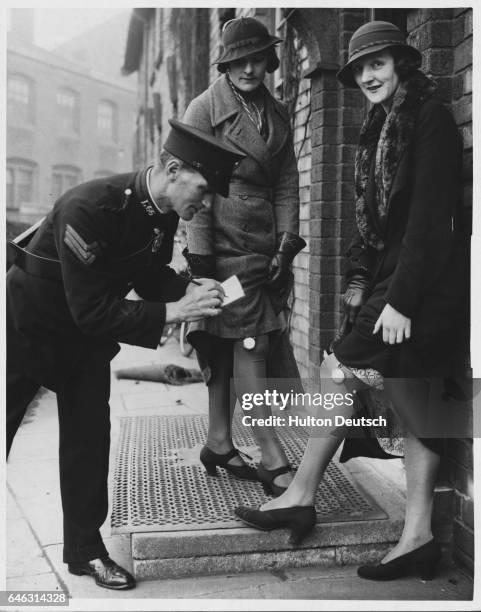 Peggy Robertshaw and Miss C. Davies have their pedometers checked after walking 12 miles to test pairs of new shoes, which is their job.