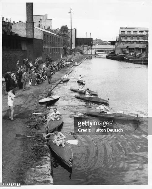 Children of the "Pitfield Canoe Club" canoe on the Grand Union Canal, London, in 1958.