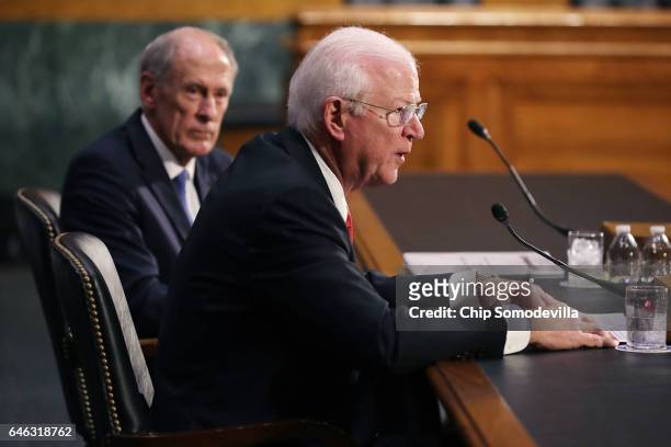 Former U.S. Senator Dan Coats listens to former Sen. Saxby Chambliss testify during Coats' confirmation hearing before the Senate Select Intelligence...