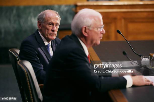 Former U.S. Senator Dan Coats listens to former Sen. Saxby Chambliss testify during Coats' confirmation hearing before the Senate Select Intelligence...