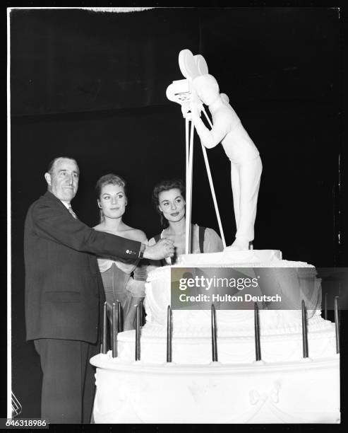 Actresses Anne Haywood and Belinda Lee watch as film magnate J. Arthur Rank cuts an enormous cake at the 21st anniversary celebrations of Pinewood...