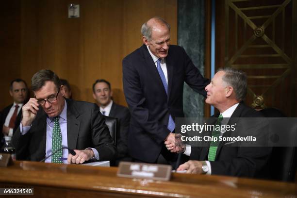 Former U.S. Senator Dan Coats greets Senate Select Intelligence Committee Chairman Richard Burr and ranking member Sen. Mark Warner before Coats'...