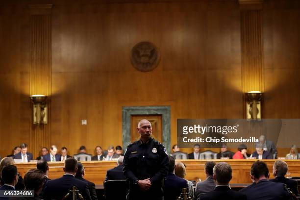 Capitol Police officer keeps an eye on the public seating as former U.S. Senator Dan Coats testifies during his confirmation hearing before the...