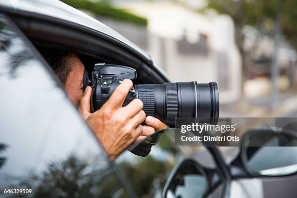 man secretly taking picture from car window - paparazzi stock pictures, royalty-free photos & images