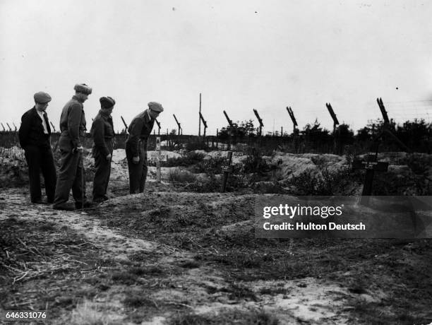 Former Russian inmates of the Belsen concentration camp visit mass graves of people killed there.