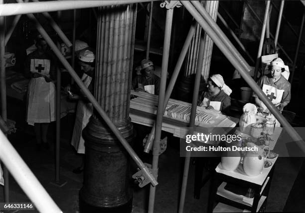 Red Cross nurses prepare bandages in a temporary hospital situated in London's Savoy Hotel, during World War II. England, ca. 1939-1945.