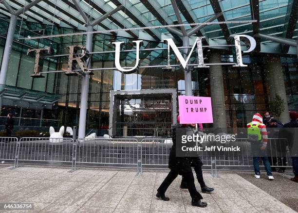 Protestors walk outside the front of the Trump International Tower & Hotel during the official opening on February 28, 2017 in Vancouver, Canada. The...