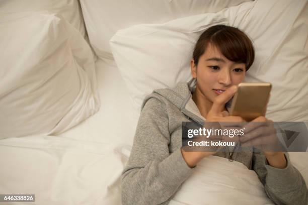 young asian girl using smartphone - bedzed stock pictures, royalty-free photos & images