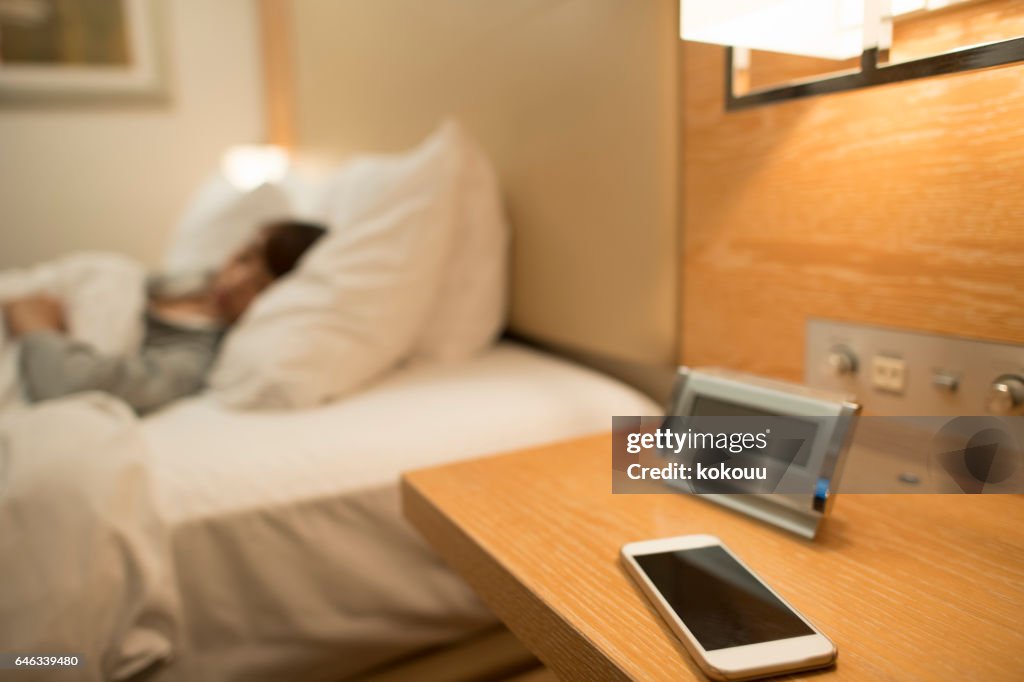 Una mujer durmiendo en un dormitorio y un smartphone