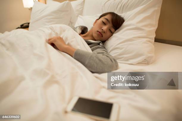 smartphone on bed - bedzed stock pictures, royalty-free photos & images