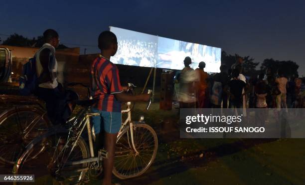 Children watch a documentary film during an open screening on the sidelines of the Pan-African Film and Television Festival in Ouagadougou on...