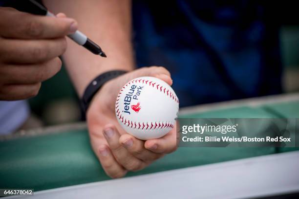 Fan holds a baseball as he waits for an autograph before a Spring Training game between the Boston Red Sox and the New York Yankees on February 28,...
