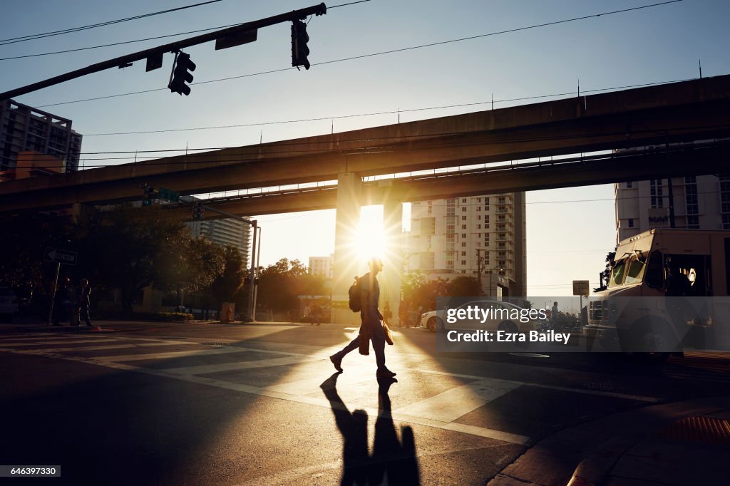 Man crossing road at sunset in Miami