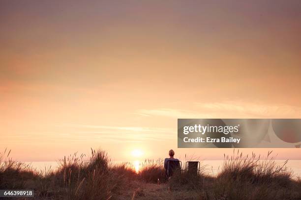woman watching the sun set - beauty in nature stock pictures, royalty-free photos & images