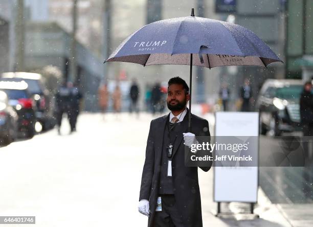 Doorman stands outside in the snow before a ceremony for the official opening of the Trump International Tower and Hotel on February 28, 2017 in...