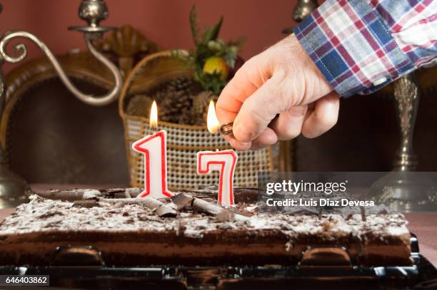 man burning candles with a lighter - número photos et images de collection