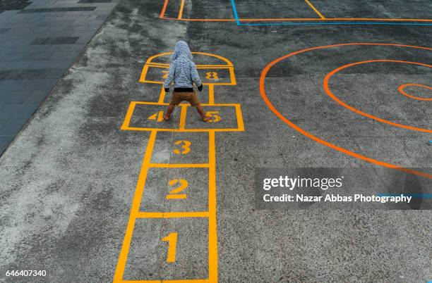 kid playing hopscotch in playground. - hopscotch stock pictures, royalty-free photos & images